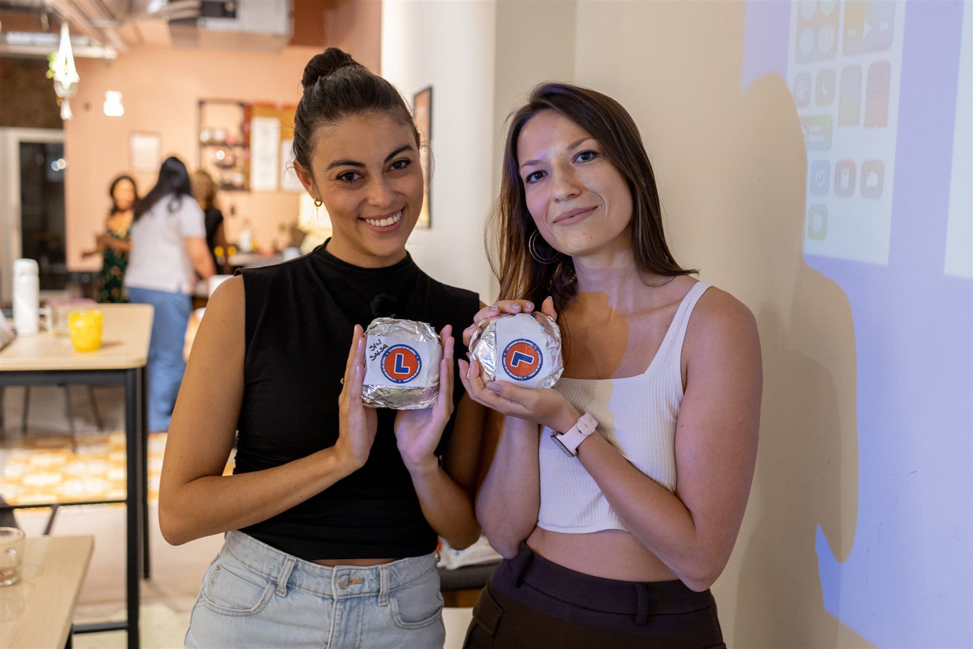 Attendees holding burgers from La Burguer de mi Amiga during a Day 1 break